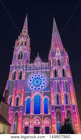 The Our Lady of Chartres cathedral illuminated during Chartres scenographic Light show. Colorful light illumine historic places and some principal buildings throughout the event.