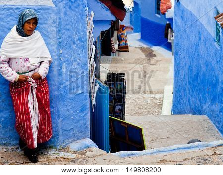 CHEFCHAOUEN, MOROCCO - JANUARY 2, 2014: Muslim women standing on the street in ancient blue Medina in Chefchaouen city.