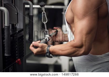 Intensive training. Strong athletic well built sportsman doing and exercise and developing his muscles while training