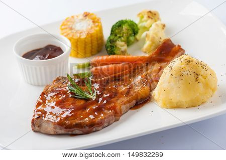 Modern style pork chop with barbecue sauce mashed potatoes grilled vegetables in ceramic dish