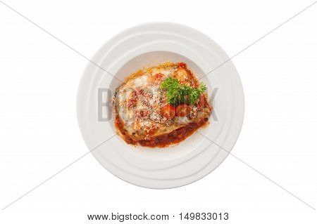 Top view of Traditional style Italian cuisine beef lasagna garnished with parmesan chesse parsley and tomatoes in ceramic dish isolated on white background