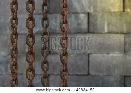 Rusty old chain hanging on over the brick wall background
