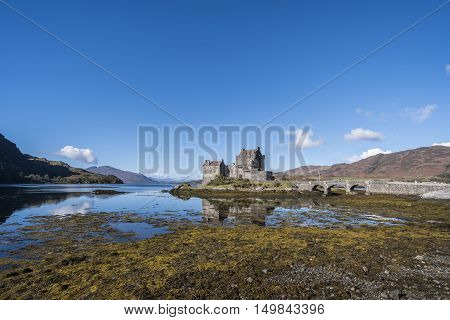 Beautiful Eilean Donan Castle 13th century fortification at Dornie Kyle of Lochalsh in the Scottish Highlands with clear blue sky and reflections