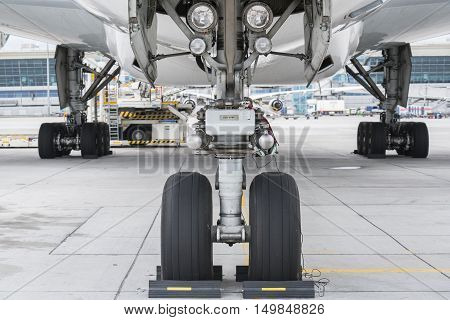 View at airfield from under wing of plane standing on parking