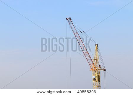 Part of yellow stationary hoist on construction site blue sky and white clouds