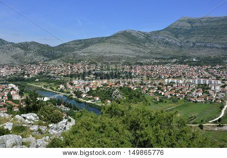 An aerial shot of the town of Trebinje in Bosnia taken from Crkvina Hill showing the historic 16th century Ottoman Arslanagica Most bridge over the Trebisnjica River.