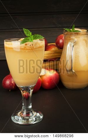 Fresh pressed apple juice unfiltered. Apple juice and apples on wooden table. A healthy juice for athletes. Autumn apple harvest.