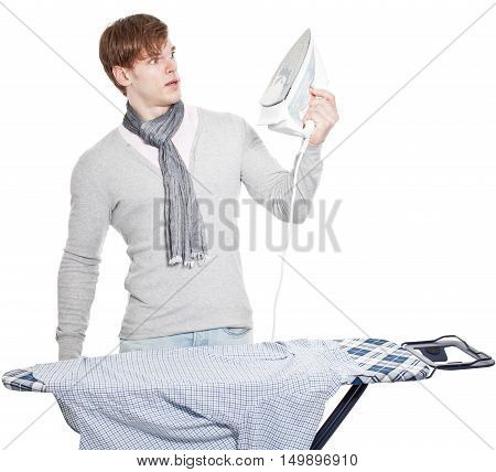 Young Man Completely Overwhelmed With His Laundry And The Electric Iron - Isolated On White Backgrou