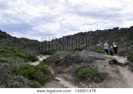 WALPOLE,WA,AUSTRALIA-SEPTEMBER 30,2014: People hiking in the lush dunes on the Great Southern Ocean coast line under cloudy skies in Walpole, Western Australia.