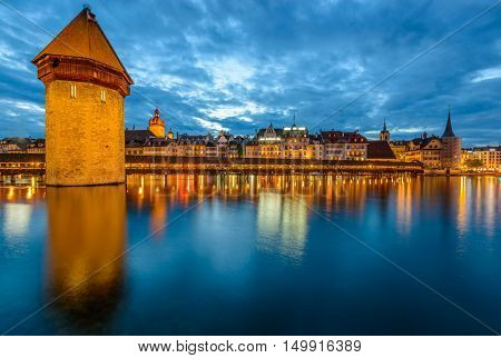 Night view towards Chapel Bridge (Kapellbruecke) together with the octagonal tall tower (Wasserturm) it is one of the Lucerne's most famous tourists attraction