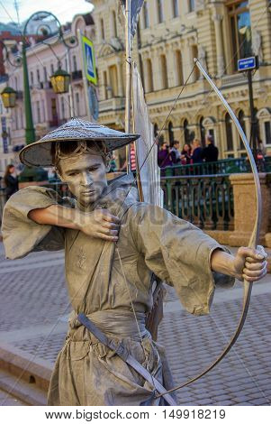 a performer - Silver painted artists on a city street living statues