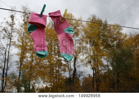 pink-and-blue socks are drying on the street