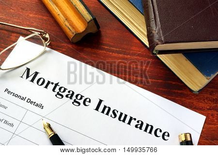 Mortgage insurance policy with a book and a pen.