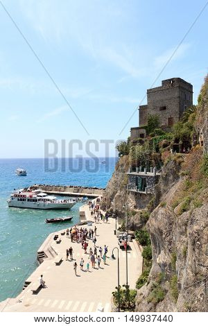 Monterosso, Italy - June 26, 2016: Port in Cinque Terre village Monterosso al Mare, Torre aurora and Mediterranean Sea. Monterosso is one of the five villages in Cinque Terre. The Torre Aurora is a famous watchtower.
