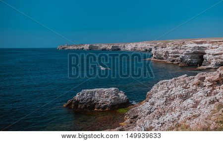 Summer view cliffed seacoast. The marine rocks landscape.. Blue sea and sky, seagal flies, beautiful nature. Black Sea bay, Crimea.