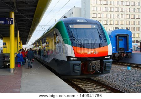 MINSK BELARUS - OCTOBER 1 2016: Unidentified people are waiting to board in electric train of business class EPM-001 of company Stadler (line Minsk-Gomel) on platform of railway station Minsk Belarus
