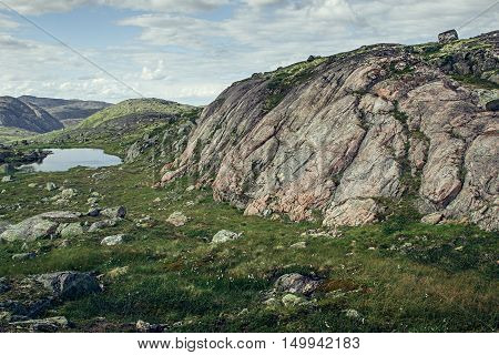 Pink granite mountain and alpine meadows in sunny day. Arctic summer the tundra Norway.