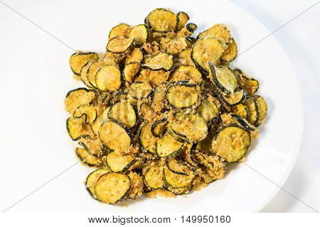 Grilled slices of crispy zucchini on a white background