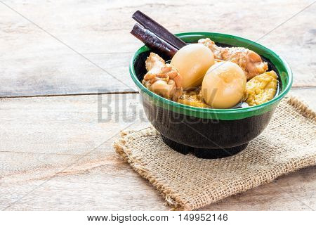 Stewed chicken eggs in the gravy in a cup on a wooden floor.its sweet tasteChinese-Thai cuisine