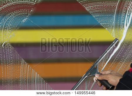 cleaner is  cleaning window  with a squeegee