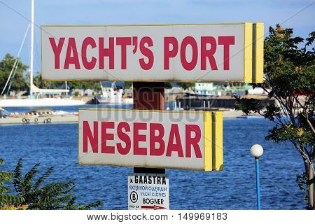 Nessebar Bulgaria - July 16 2016: Yacht's Port Of Nessebar Sign On A Pole in Nessebar. Bulgarian Black Sea Coast On The Background