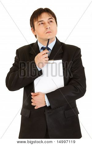 화이트에 고립 된 그의 턱 근처 펜을 들고 클립보드와 잠겨있는 사업가