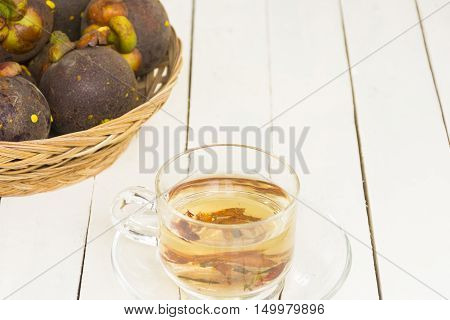 Mangosteen juice from herbs and mangoteen  in the basket on wooden white background.Top view and zoom in.
