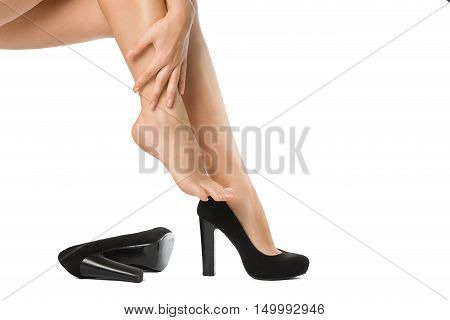 Woman unshoed her legs. Bare legs of the woman with her hand isolated on white. Beautiful skin. Foot care