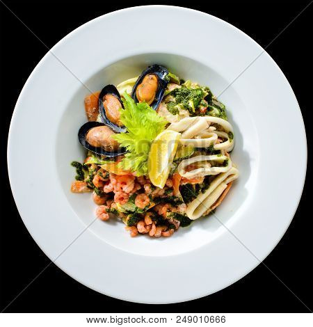 Fresh Seafood Salad With Prepapred Clams, Shrimp And Lemon In A White Plate Isolated On Black Backgr