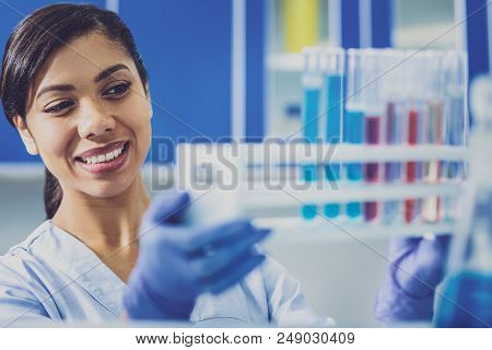 Appealing Biologist. Beaming Appealing Biologist Feeling Inspired While Taking Bulbs With Chemicals 