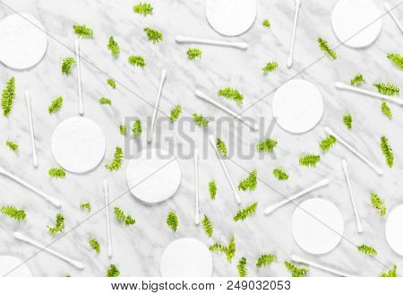 Cotton Pads, Q-tips And Green Leaves On Marble Background. Flat Lay Composition.