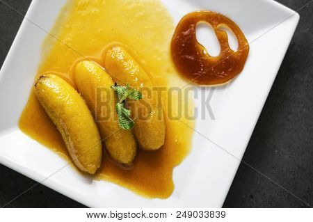 Gourmet Flambeed Fried Banana In Orange Juice Reduction Sauce And Tangerine Caramel Chip