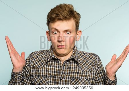 Uncomprehending Bewildered Puzzled Perplexed Confused Man. Portrait Of A Young Guy On Light Backgrou
