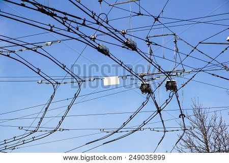 Black Tram Wires Over Blue Sky . Urban Transportation System