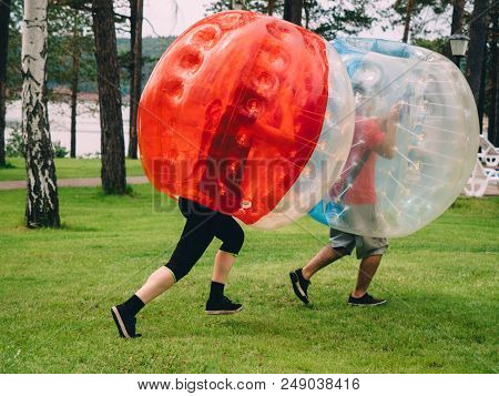 People Play Bumperball Zorbsoccer Outdoor. Summer Time