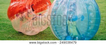People Play Bumperball Zorbsoccer Outdoor. Summer Time