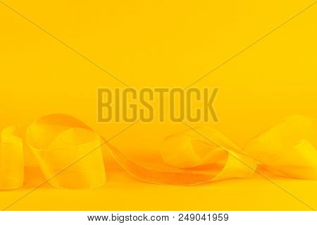 Bright Yellow With Tender Ribbon. Festive Background With Copy Space.