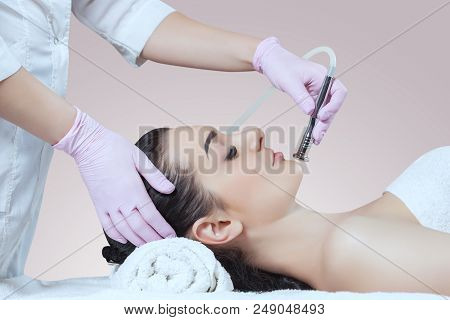 The Cosmetologist Makes The Procedure Microdermabrasion Of The Facial Skin Of A Beautiful, Young Wom