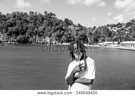 Castries, St.lucia - November 26, 2015: African Man Show Victory Or Peace Gesture On Blue Sea. Old H
