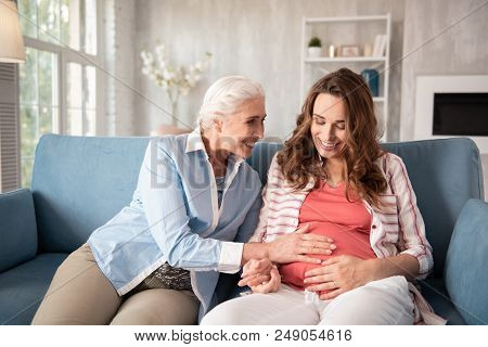 Kind-hearted Mother. Kind-hearted Mother Sitting On Comfortable Blue Sofa Coming For Visiting Her Pr
