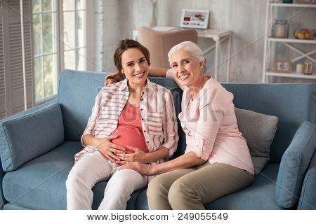 Discussing Childbirth. Beaming Woman Wearing Nice Pink Shirt Discussing Childbirth With Her Expectin