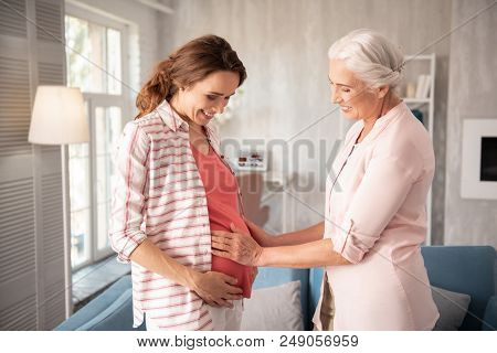 Two Generations. Two Generations Spending Their Free Time Together While Standing Near Blue Sofa In 
