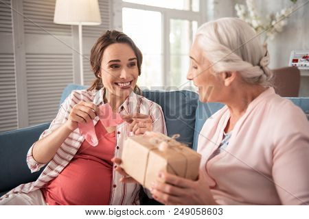Little Presents. Dark-eyed Expecting Woman Feeling Really Surprised While Receiving Little Presents 