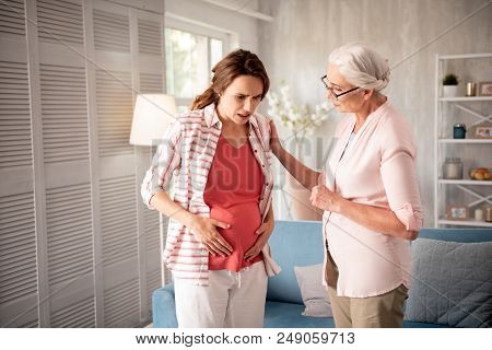 Unexpected Pain. Pregnant Woman Feeling Unexpected Strong Pain In Her Tummy While Visiting Her Lovin