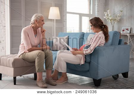 Planning Childbirth. Woman Wearing Baggy Clothes And Nice Black Glasses Feeling Excited While Planni