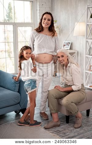 Beige Trousers. Aged Beautiful Woman Wearing Stylish Beige Trousers Visiting Her Pregnant Daughter