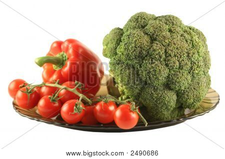 Brokolice, paprika a rajčata na desku na bílém pozadí