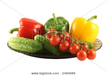 Brokolice, okurky, paprika a rajčata na desku na bílém pozadí
