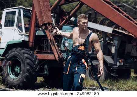 Power Concept. Power Man Pull Tractor With Crane. Power Lifter At Construction Site. Feel The Power.