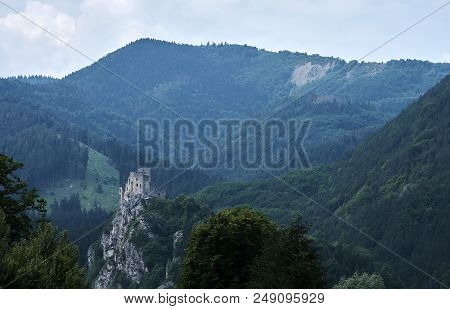 View Of A Mountain Landscape With Forest And Ruins Of Strecno Castle In Slovakia, Under Blue Sky